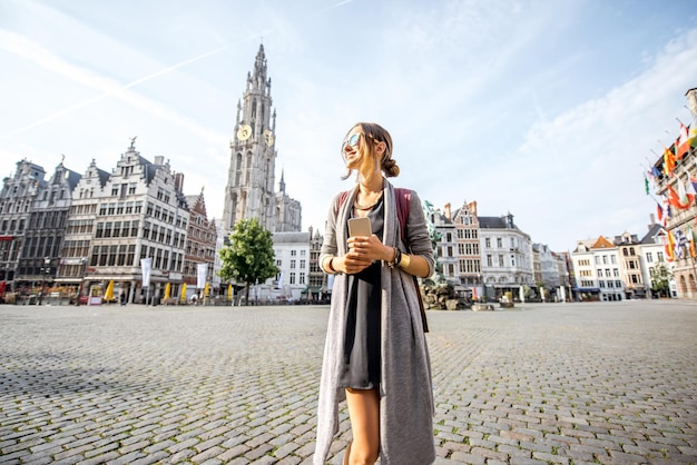 Turista joven caminando por la gran plaza del mercado durante la mañana en Amberes, Bélgica