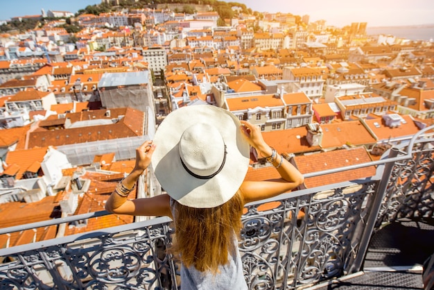 Turista joven disfrutando de la hermosa vista superior del paisaje urbano en el casco antiguo durante el día soleado en la ciudad de Lisboa, Portugal