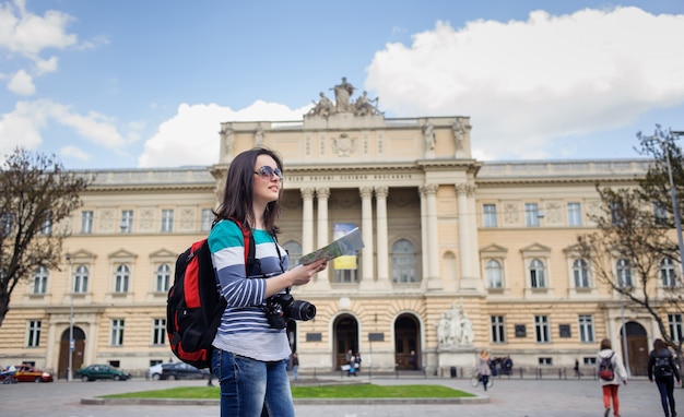 Turista joven con mapa y cámara