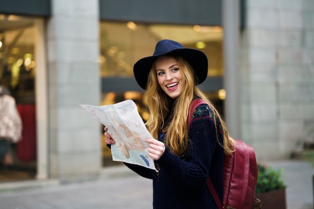 Turista joven con un mapa en una ciudad