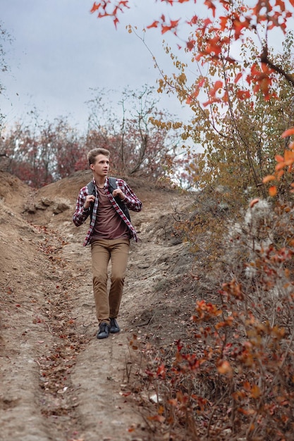 Turista joven con mochila caminando por el sendero en la naturaleza. chico de excursión