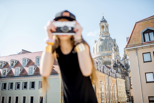 Turista joven de pie con cámara de fotos en la famosa terraza Bruhl con gran vista sobre el casco antiguo de Dresde, Alemania. Imagen centrada en el fondo