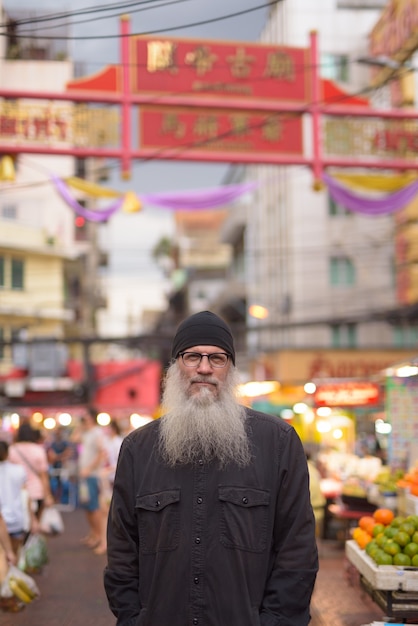 Turista maduro barbudo com óculos em Chinatown