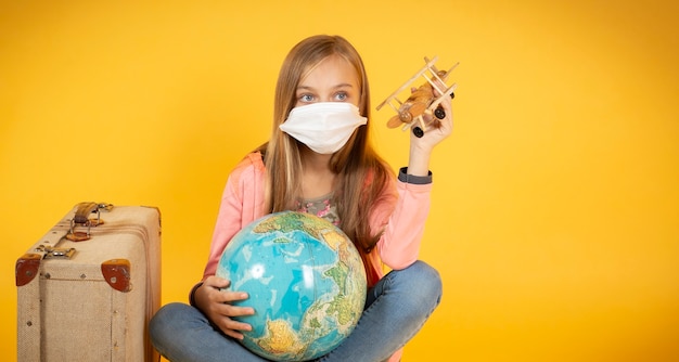 Una turista con máscara médica, brote de coronavirus COVID-19. Concepto de viajes cancelados. Un turista no puede irse debido a una pandemia.