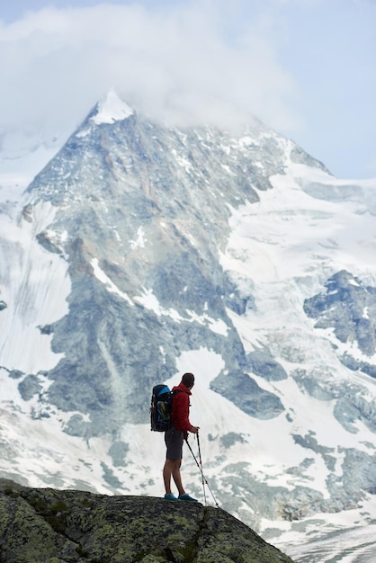 Turista masculina escalando penhascos rochosos nevados de belos alpes penning na suíça