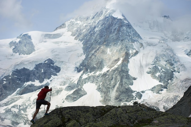 Turista masculina escalando penhascos rochosos nevados de belos Alpes Penning na Suíça