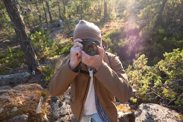 Foto turista masculina usando câmera digital ao ar livre em uma floresta