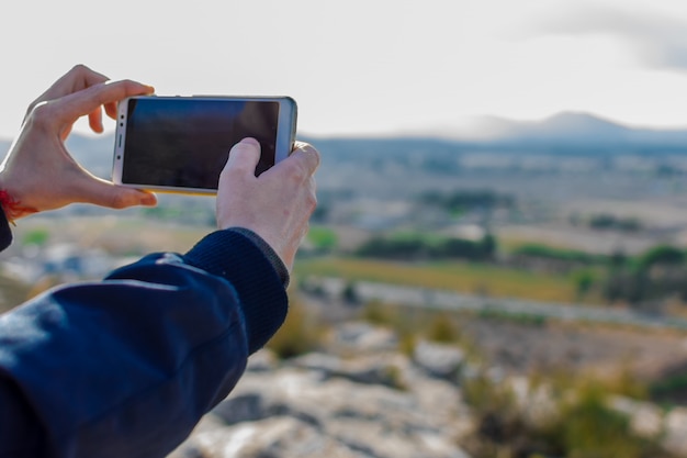 Turista masculino está tomando la foto con la cámara del teléfono móvil