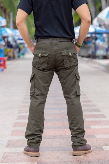 Foto turista masculino que lleva los pantalones cargo que se colocan en el parque.