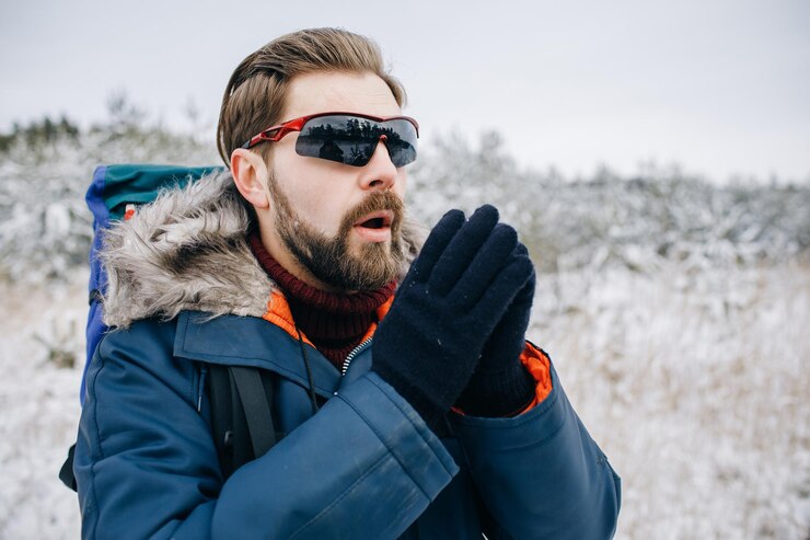 Turista masculino tratando de calentarse las manos