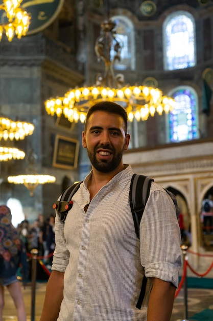 Turista masculino velado joven que visita el interior de la mezquita de Hagia Sophia