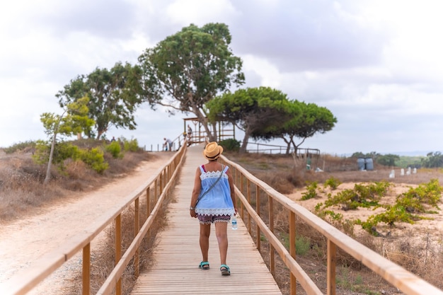 Un turista mayor caminando junto a la laguna en el Parque Natural de La Mata en Torrevieja Alicante