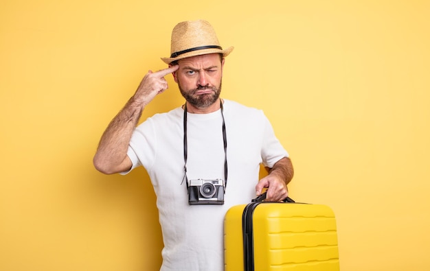 turista de mediana edad que se siente confundido y desconcertado, mostrando que estás loco. concepto de viaje