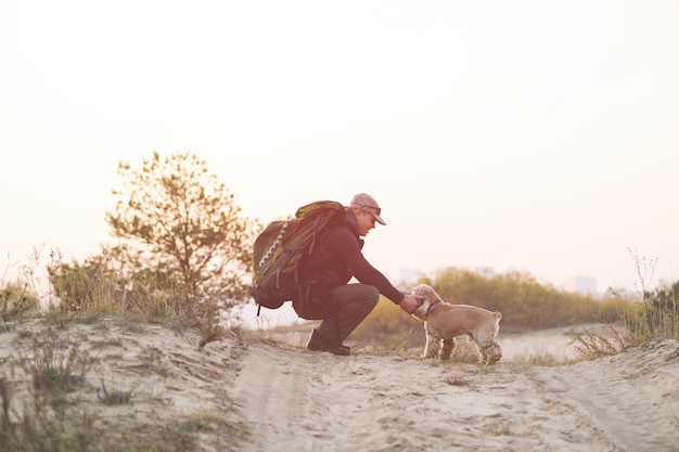 Turista con mochila sentarse con perro mascota