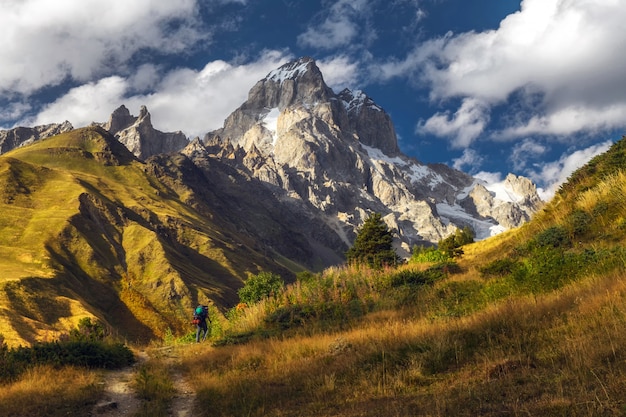 Foto turista mochilero en una ruta en las montañas