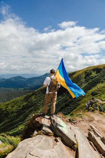 Un turista en las montañas con una bandera ucraniana