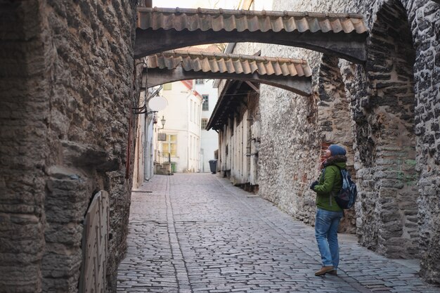 Turista mujer caminando en el casco antiguo de Tallin solo viajando vacaciones en la calle medieval de Estonia