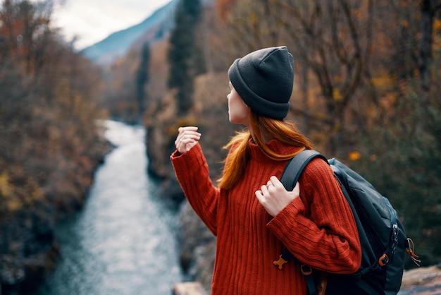 Turista de mujer con mochila en el puente por el viaje del río