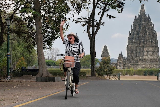 Foto una turista mujer montando una bicicleta de alquiler en el parque nacional del templo de prambanan yogyakarta indonesia