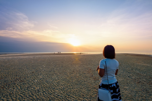 Turista de mujeres de pie en la playa mirando el hermoso paisaje natural, colorido del cielo y el mar durante una puesta de sol en Nathon Sunset Viewpoint en la isla de Ko Samui, Surat Thani, Tailandia