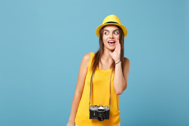 turista mulher com roupas casuais de verão amarelo e chapéu com câmera fotográfica azul