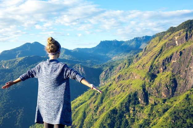 Turista de niña en la cima de la montaña en los rayos del amanecer, Sri Lanka