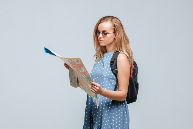 Turista de niña con una mochila mirando el mapa