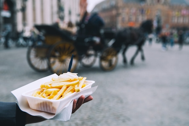 Turista oferece comida popular de rua com Batatas Fritas na Holanda Amsterdã Holanda