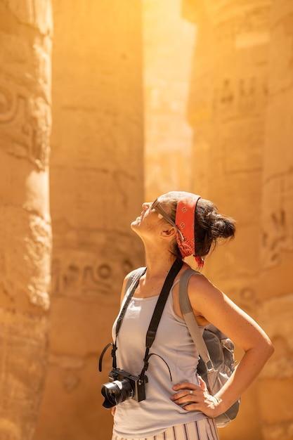 Turista olhando para colunas com hieróglifos em um templo