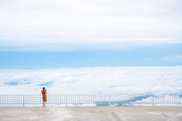 Turista de pie en el acantilado mirando la hermosa niebla, Phu Tub berk Tailandia