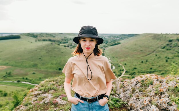 Foto turista con ropa informal sobre una roca en la montaña sobre un fondo de hermoso paisaje