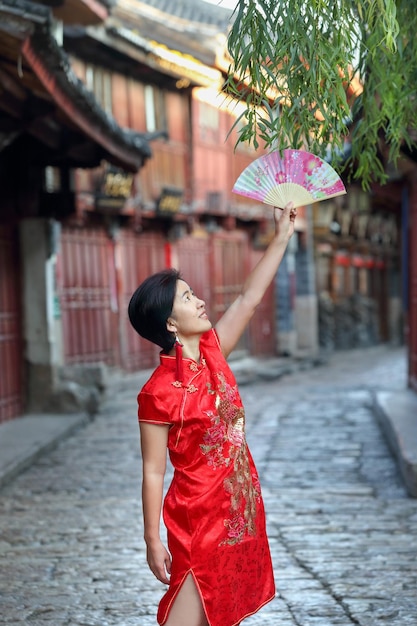 Turista con ropa tradicional china en el casco antiguo de Lijiang, Yunnan, China