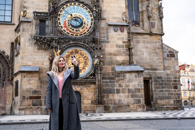 turista rubia cerca del famoso reloj de Praga, República Checa