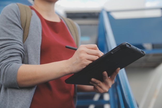 Una turista rubia chequeando la notificación entrante en su teléfono inteligente sentada en el asiento del avión con un netbook Una joven mujer de negocios comparte medios desde el teléfono a la computadora portátil durante el vuelo en avión