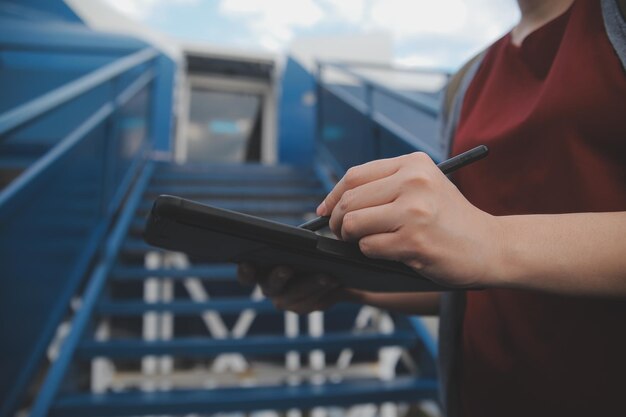 Foto una turista rubia chequeando la notificación entrante en su teléfono inteligente sentada en el asiento del avión con un netbook una joven mujer de negocios comparte medios desde el teléfono a la computadora portátil durante el vuelo en avión