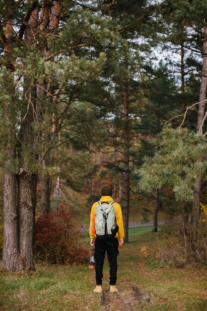 Turista en una ruta de senderismo en el bosque con una mochila y una lámpara