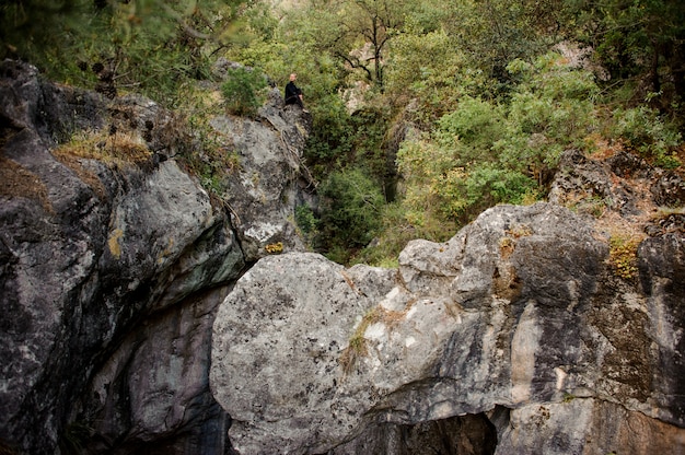 Turista sentada en el bosque de montaña