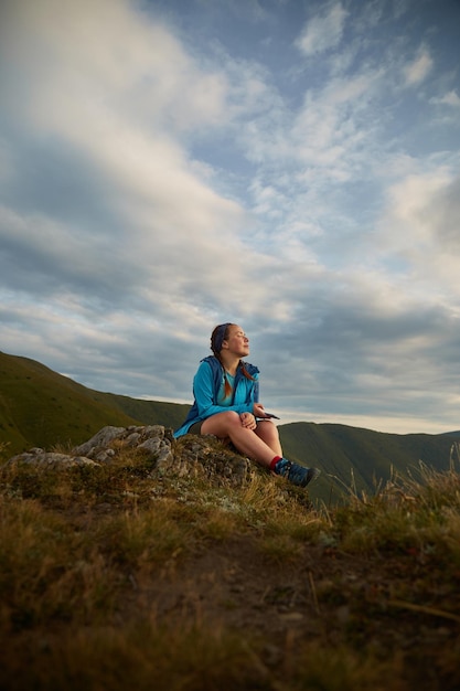 Turista sentada y disfrutando de la vista de la cordillera de los Cárpatos Ucrania Rutas de senderismo y caminatas en la cresta de Borzhava Área rural de las montañas de los Cárpatos en otoño