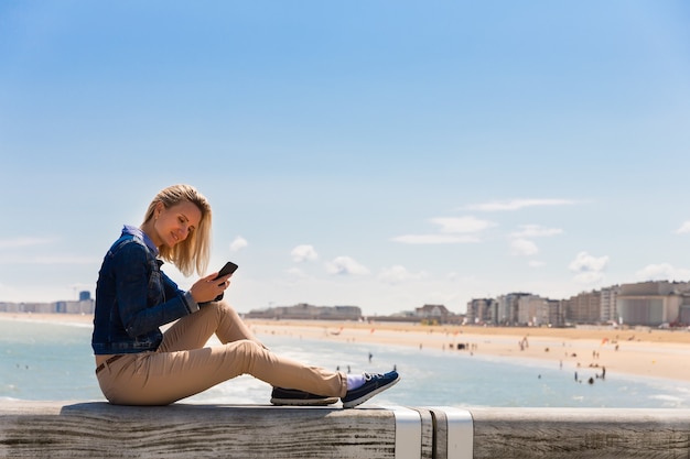 Turista sentado en el muelle en la playa de la ciudad, costa del mar, Europa. Turismo y viajes de verano, lugares famosos y populares para viajes de vacaciones o vacaciones.