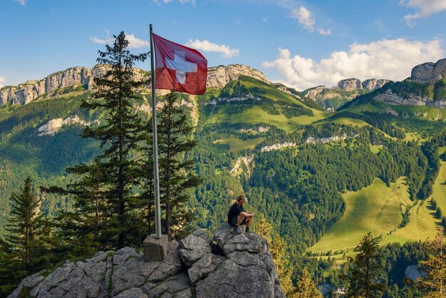 Turista sentado na montanha Ebenalp nos Alpes suíços da Suíça