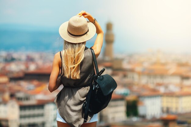 Turista sonriente joven atractiva de la muchacha que explora la nueva ciudad en verano