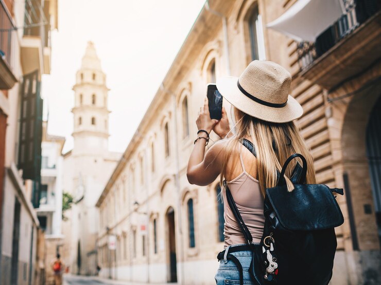 Foto turista sonriente joven atractiva de la muchacha que explora la nueva ciudad en verano