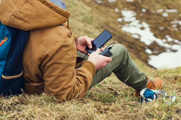 El turista sostiene un cargador portátil con un teléfono inteligente en la mano