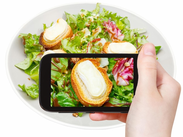 Turista tirando foto de salada verde com queijo