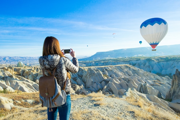 Turista tomando fotos de globos aerostáticos en Capadocia