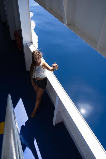 Turista tomando Selfie con su teléfono inteligente sonriendo en un ferry