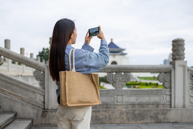 Una turista usa su teléfono móvil para tomar una foto en el Chiang Kai Shek Memorial Hall en Taiwán