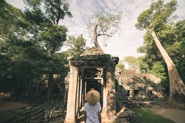 Un turista visitando las ruinas de Angkor en medio de la jungla.