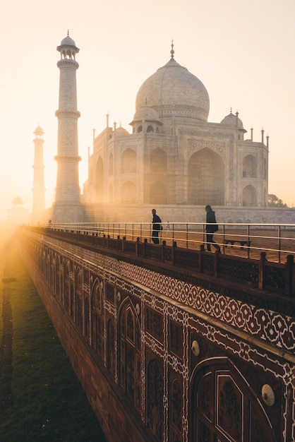 Foto turista visitando el taj mahal durante el amanecer