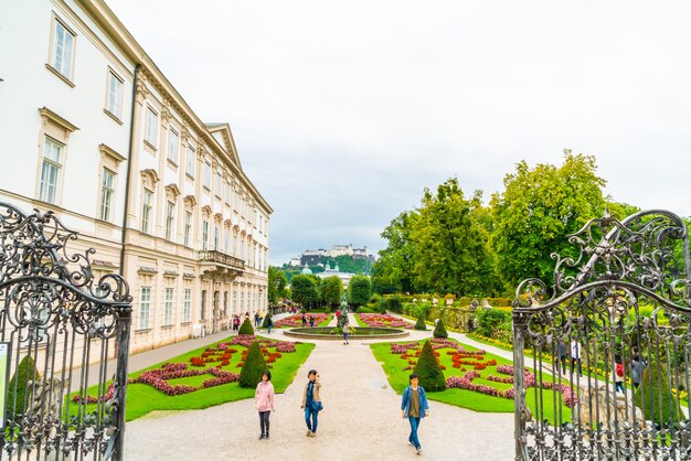 Turistas andando pelo palácio e jardins mirabell